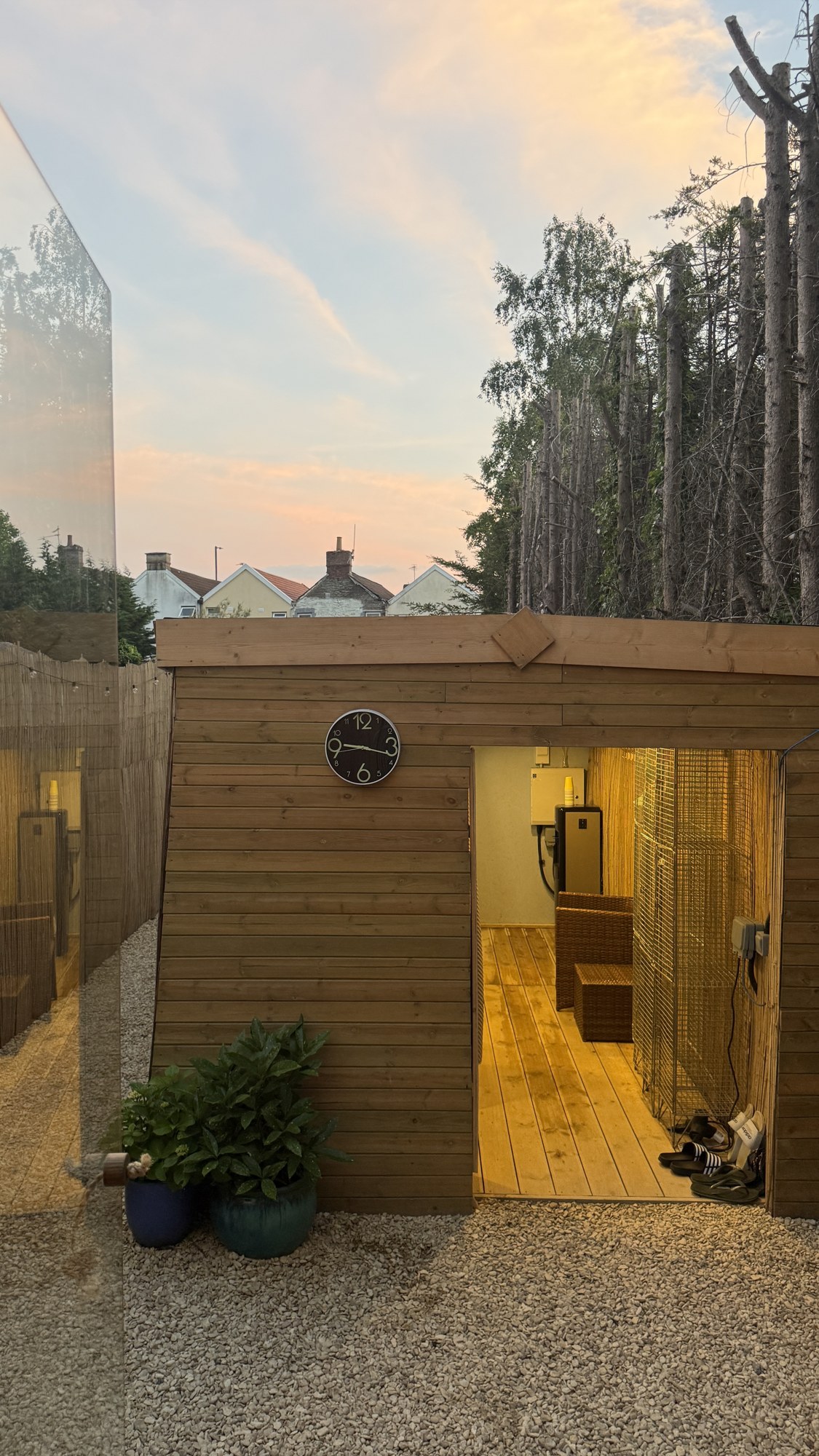 Timber-clad Wild Sauna entrance lit at dusk